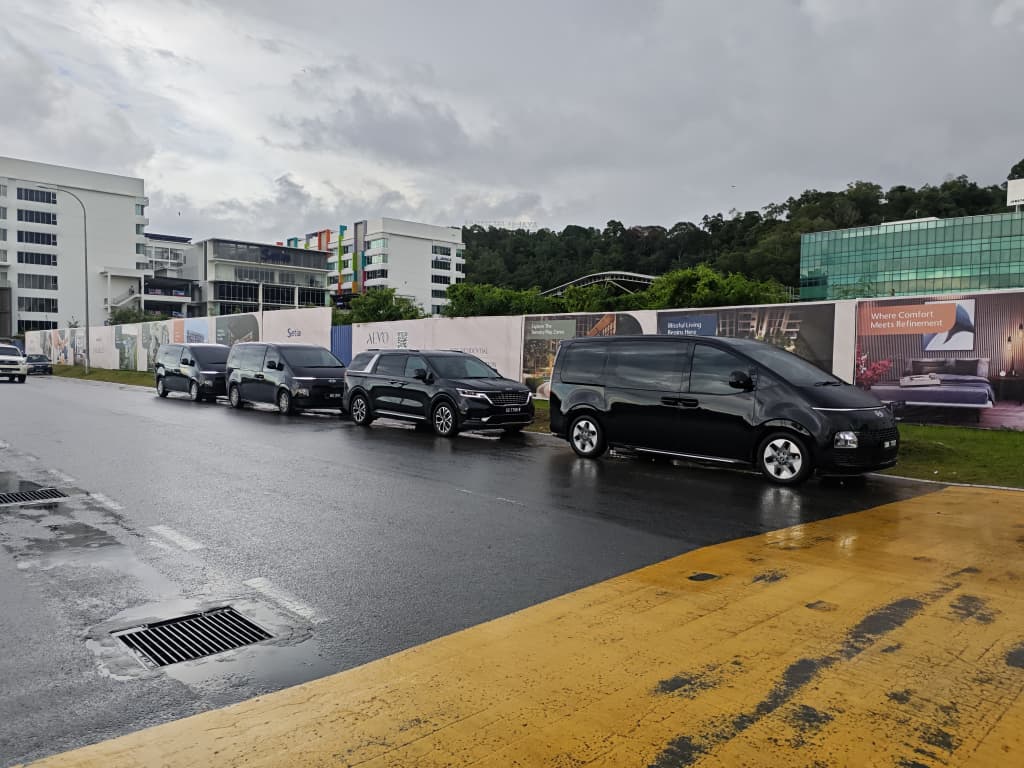 ZahraGO rental fleet parked on a rainy street in Kota Kinabalu