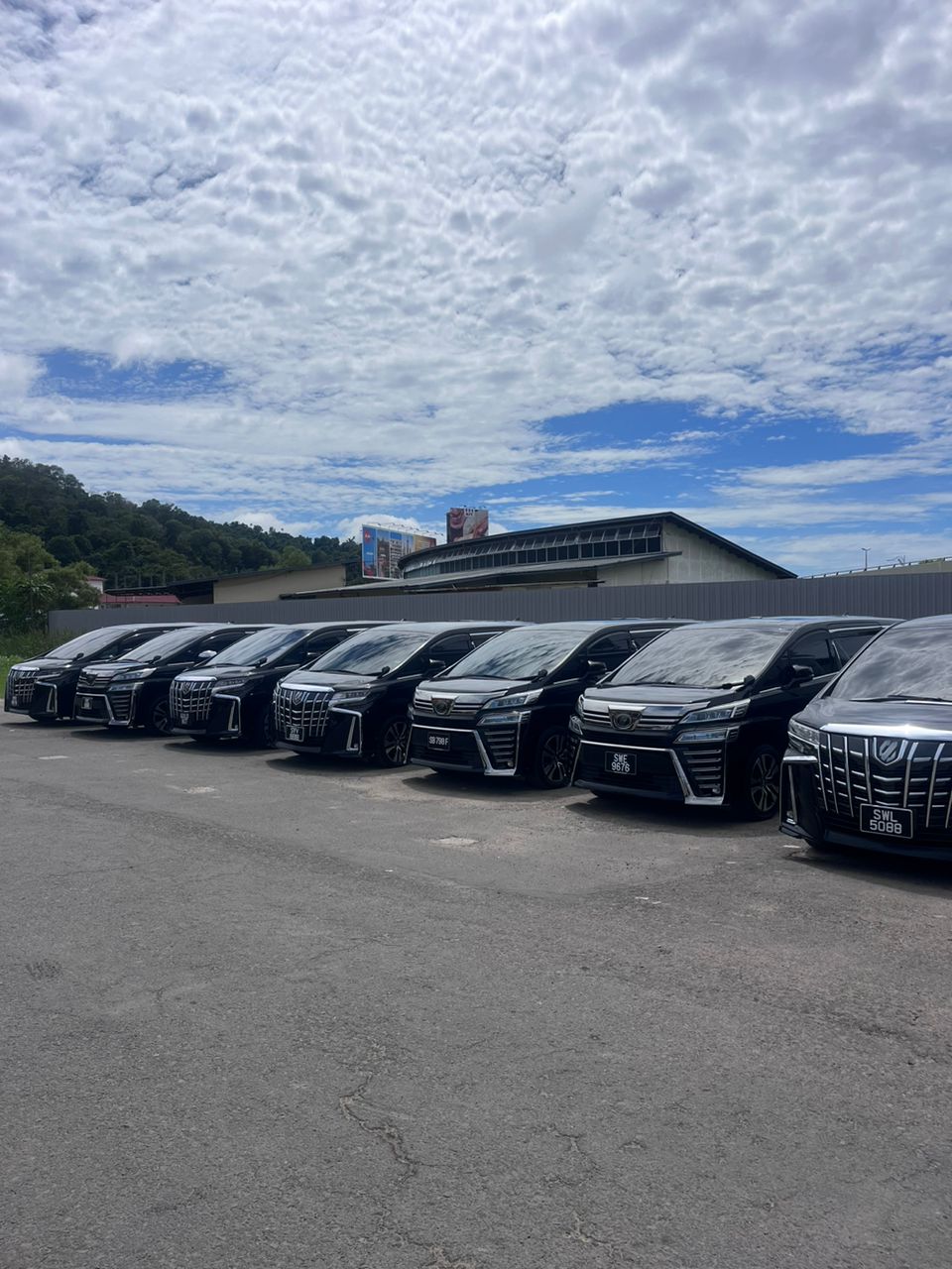 Row of black Toyota Alphard and Vellfire MPVs from the ZahraGO rental fleet, Sabah